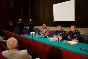 Zdjęcie przedstawia policjantów rozmawiających z seniorami podczas debaty.