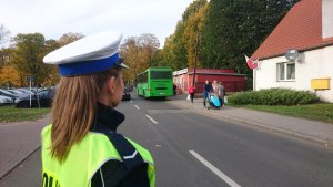 Zdjęcie przedstawia policjantkę obserwującą ruch na drodze.