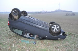 Zdjęcie przedstawia samochód, który uczestniczył w zdarzeniu drogowym. Rozbity leży na dachu.