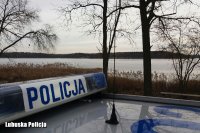 belka na dach radiowozu z napisem policja, w tle jezioro