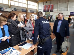 policjant rozmawiający z młodzieżą na targach