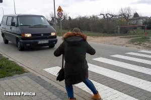 kobieta w słuchawkach na uszach cofa nogę z przejścia dla pieszych, przed pasami blisko nadjeżdża bus