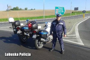 policjant stojący przy motocyklu