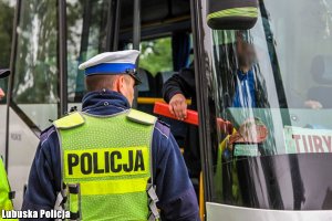 policjant kontrolujący autobus