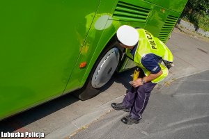 policjant kontrolujący autobus