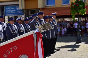 Szyk policjantów na tle części sztandaru