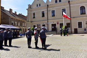 Poczet sztandarowy a w tle poczet flagowy i powiewająca flaga