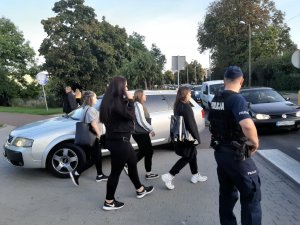 Policjant za dnia nadzorujący bezpieczeństwo w rejonie wjazdu na festyn