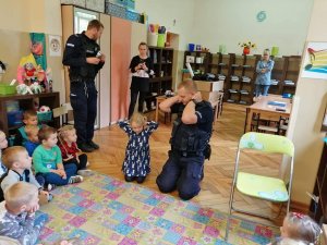 policjant prowadzący z dziećmi zajęcia profilaktyczne