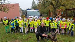 dzieci stojące z policjantem