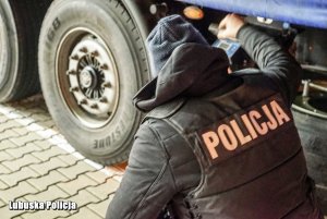 policjant sprawdzający koła pojazdu