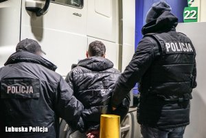 policjanci prowadzący osobę zatrzymaną