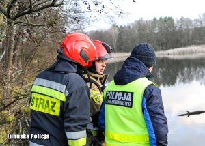 policyjny technik kryminalistyki i strażak stojący przy rozlewisku