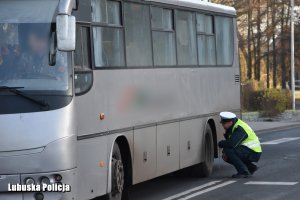 funkcjonariusz sprawdzający stan techniczny autobusu