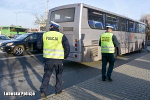 funkcjonariusze stojący przy autobusie