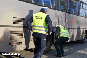 funkcjonariusze sprawdzający stan techniczny autobusu