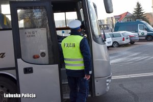 policjant stojący przy wejściu do autokaru