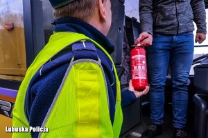 kierowca autobusu pokazujący policjantowi gaśnicę