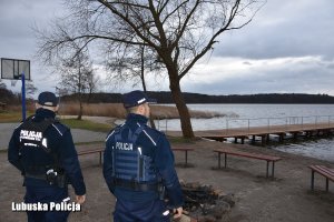 dwóch policjantów stojących przy miejscu ogniskowym na plaży