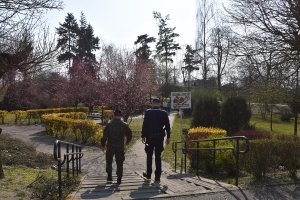 policjant i żołnierz idący w parku