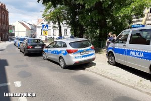 stojące na chodniku dwa radiowozy, przed nimi samochód zatrzymanego marki BMW, za nim kolejne radiowozy