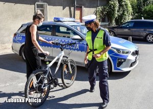 Policjantka i rowerzystka na tle radiowozu podczas kontroli