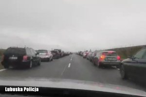 Korytarz życia na autostradzie A2, po lewej i prawej na poboczu pojazdy, radiowóz jedzie środkiem