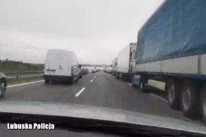 Korytarz życia na autostradzie A2, po lewej i prawej na poboczu pojazdy, radiowóz jedzie środkiem