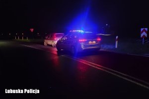 Noc, przy drodze stoi auto a za nim na sygnałach radiowóz