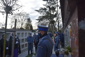 Komendant przemawiający na pogrzebie, w tle urna, warta honorowa oraz miejsca gdzie składa się urny