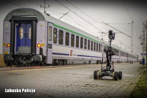 Peron, w tle pociąg w którego kierunku jedzie robot pirotechników.