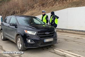 Policjanci rozmawiają z kierowca jadącym od granicy