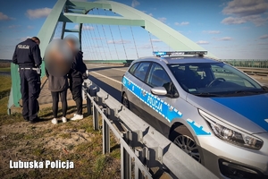 Policjant z dwójką młodych osób przy wiadukcie nad trasą S3