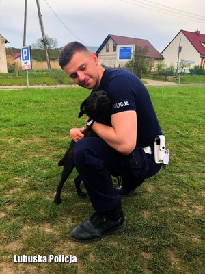Kucający policjant i przytulający się do niego pies
