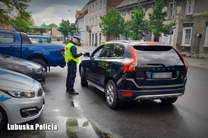 policjant zatrzymujący na ulicy auto do kontroli