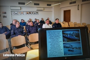 Zza laptopa na mównicy widok na siedzących policjantów