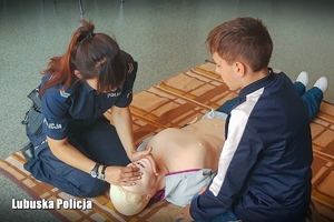 Policjantka pokazuje elementy udzielania pierwszej pomocy