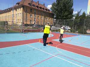 Policjant oceniający jazdę na rowerze ucznia podczas egzaminu na kartę rowerową