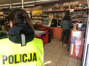 Policjanci w markecie, w tle stoisko z alkoholem