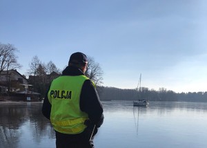 Policjant na pomoście przy jeziorze