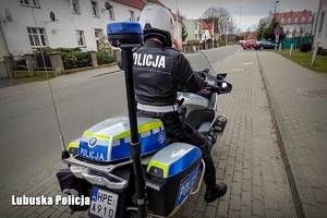 Policjant na oznakowanym motocyklu, widok od tyłu.