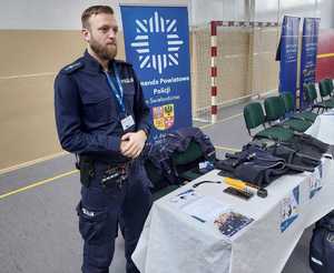 Policjant przy stoisku promocyjnym