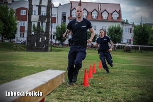 Policjanci biegnący po torze przeszkód