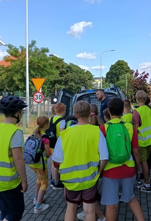 Policjant pokazujący dzieciom wnętrze radiowozu.