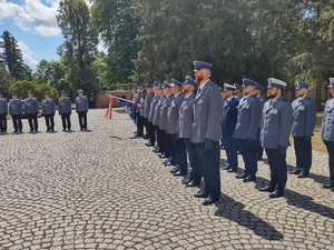 Policjanci wytypowani do awansu, poczet sztandarowy oraz kadra na placu podczas uroczystości