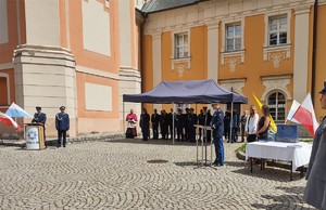 Komendant wojewódzki przemawia, w tle namiot z gośćmi.