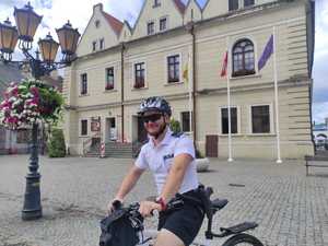 Policjant na rowerze przed ratuszem.