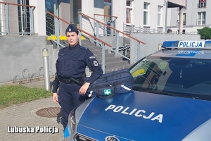 Policjantka przy radiowozie z torbą medyczną.