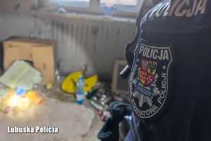Widok na miejsce nocowania bezdomnego, w pierwszym tle ręka policjanta.