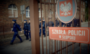 brama do szkoły policji, w tle wychodzący kursanci